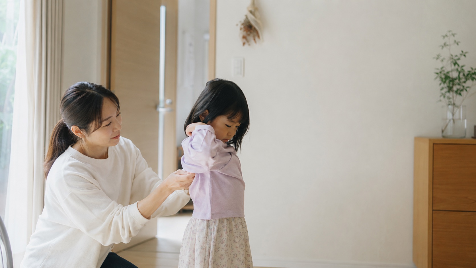 子どもの着替えを見守る保護者